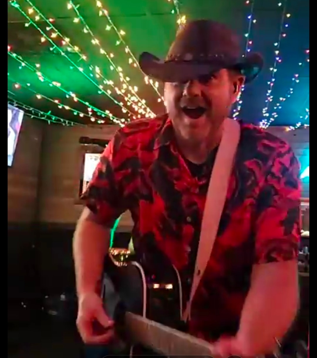 John D Parker performing live under string lights